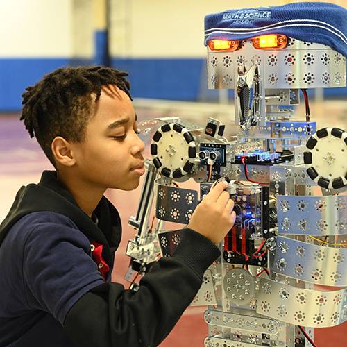 Young boy builds a robot